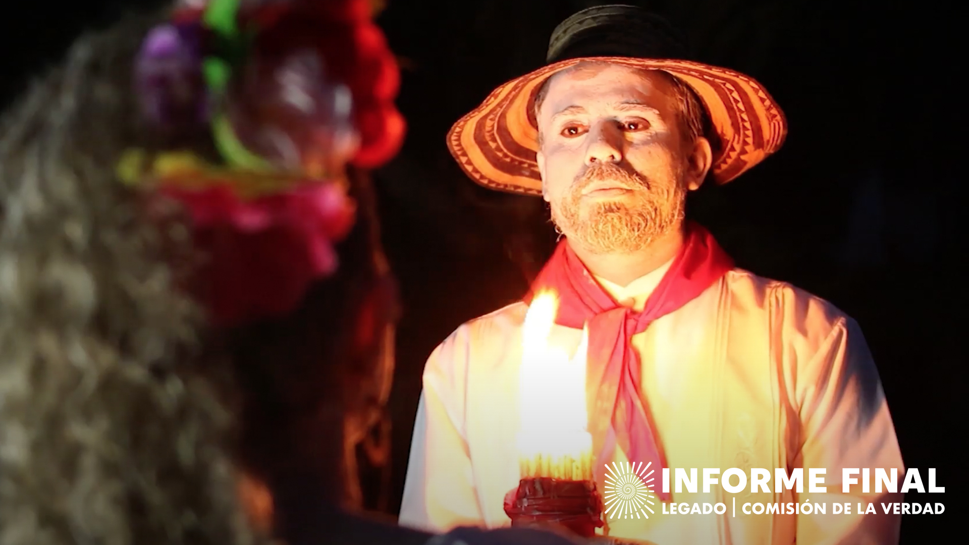 Hombre de sombrero mirando fijamente con una vela encendida en sus manos