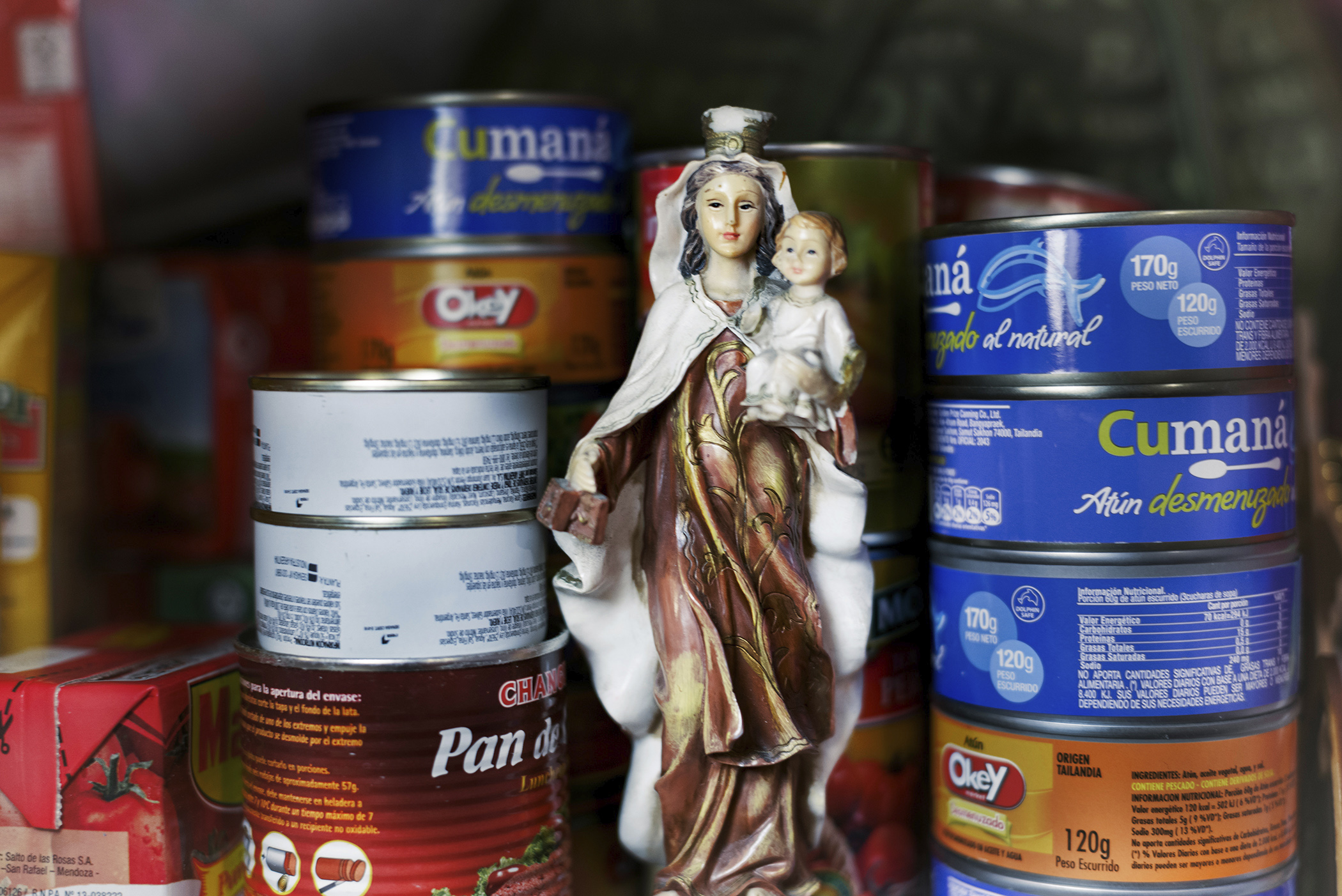 Vírgen cargando niño entre latas de atún