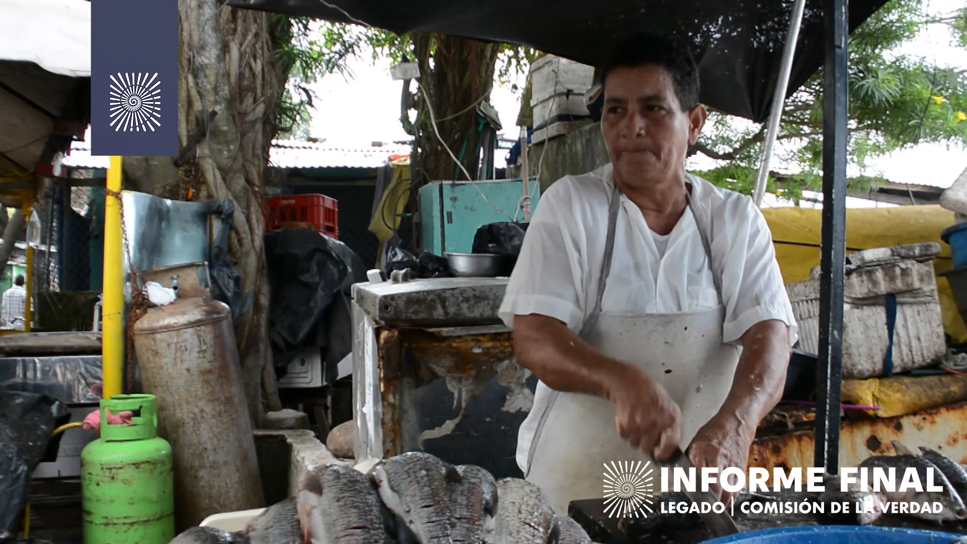 Mujer campesina con delantal y camisa blanca corta pescado.