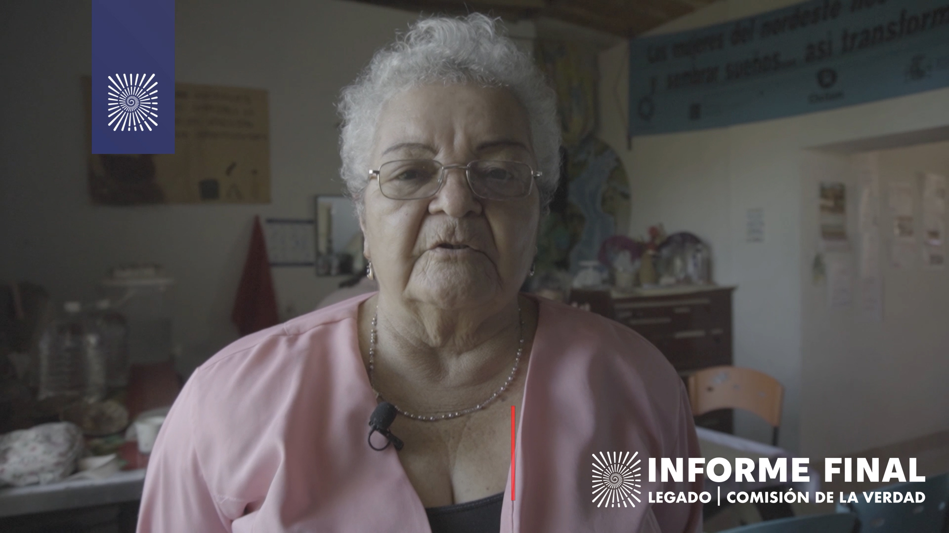 Mujer mayor blanca, de pelo blanco y gafas mira a cámara mientras habla