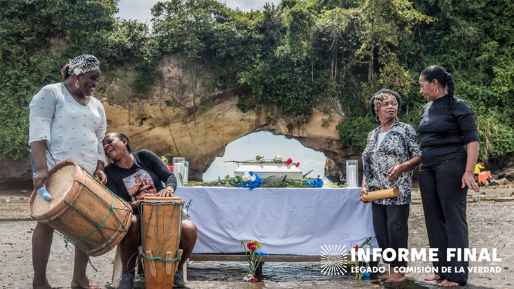 Agrupación de mujeres conversan y ríen entre sí en la playa