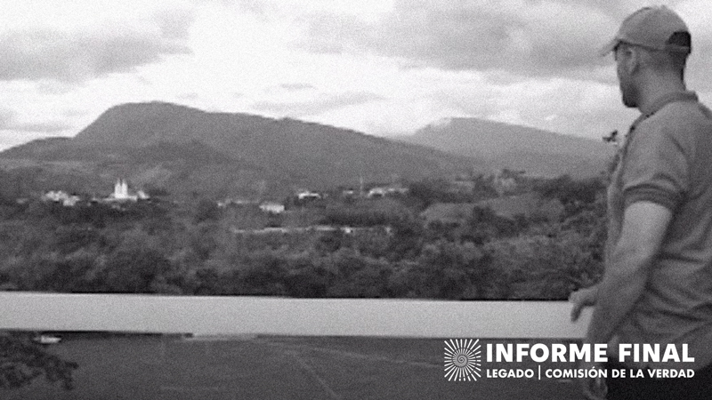 En blanco y negro. Hombre con gorra mira panorámica de un pueblo