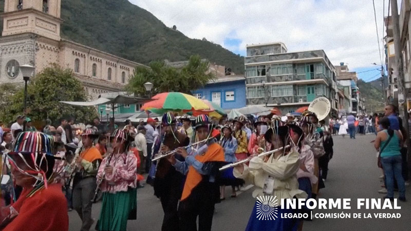 Indígenas tocan sus instrumentos y caminan por la calle.