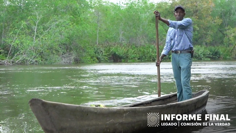 Lidoro Hurtado de pie sobre una canoa y con un remo en la mano