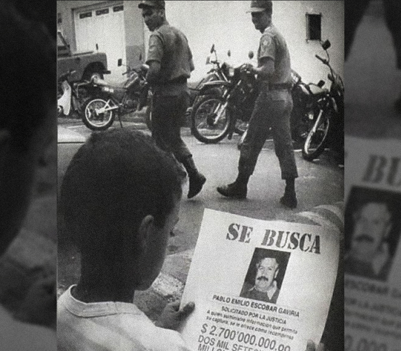 Niño sostiene panfleto de SE BUSCA a Pablo Escobar